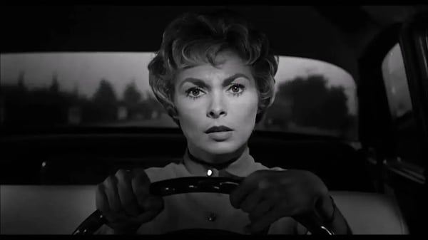 Janet Leigh from Hitchcock's, "Psycho," driving with a concerned look.