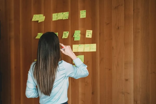 Woman outlines a script with post-it notes.