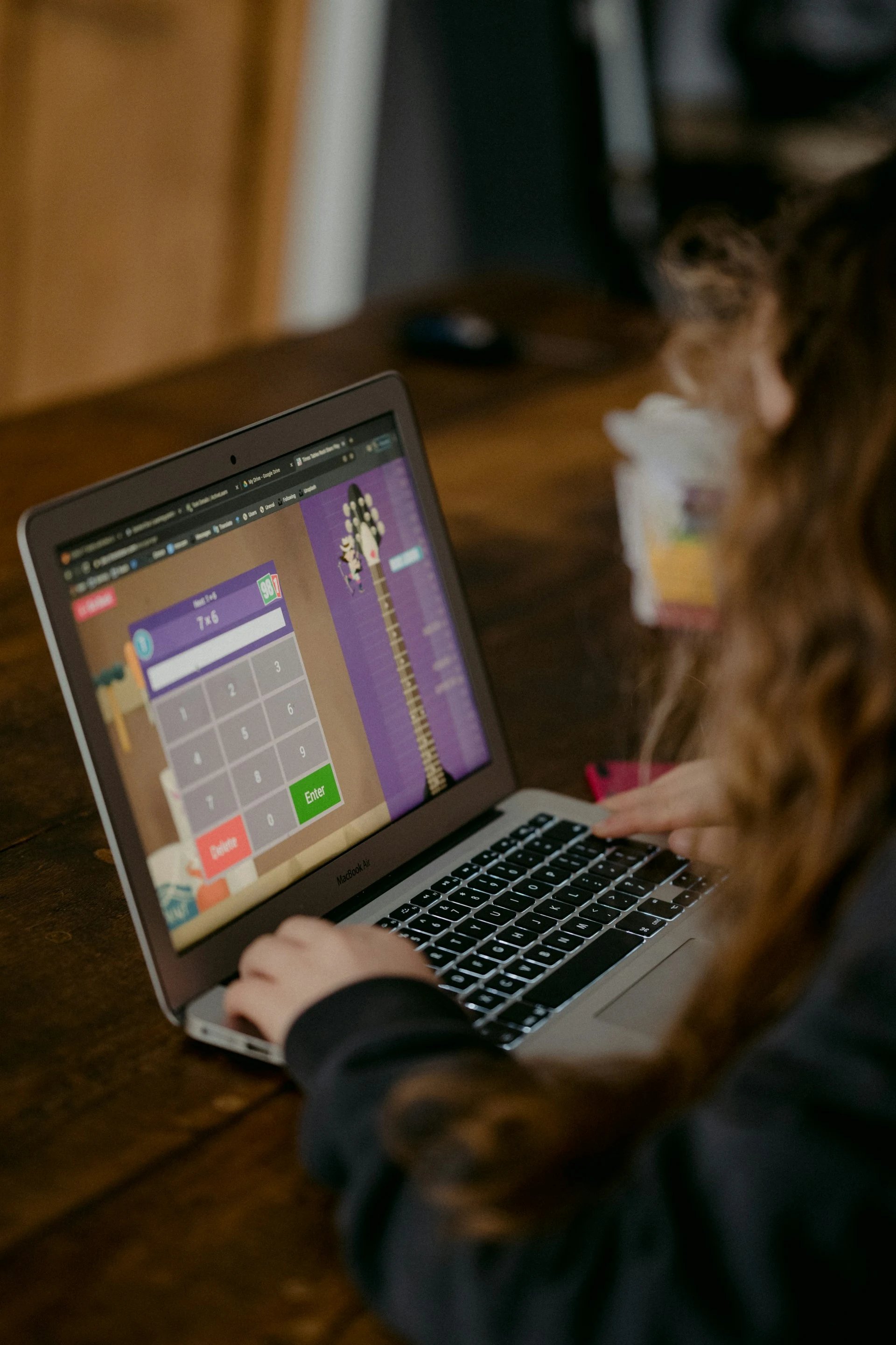 Young girl doing school work on laptop.