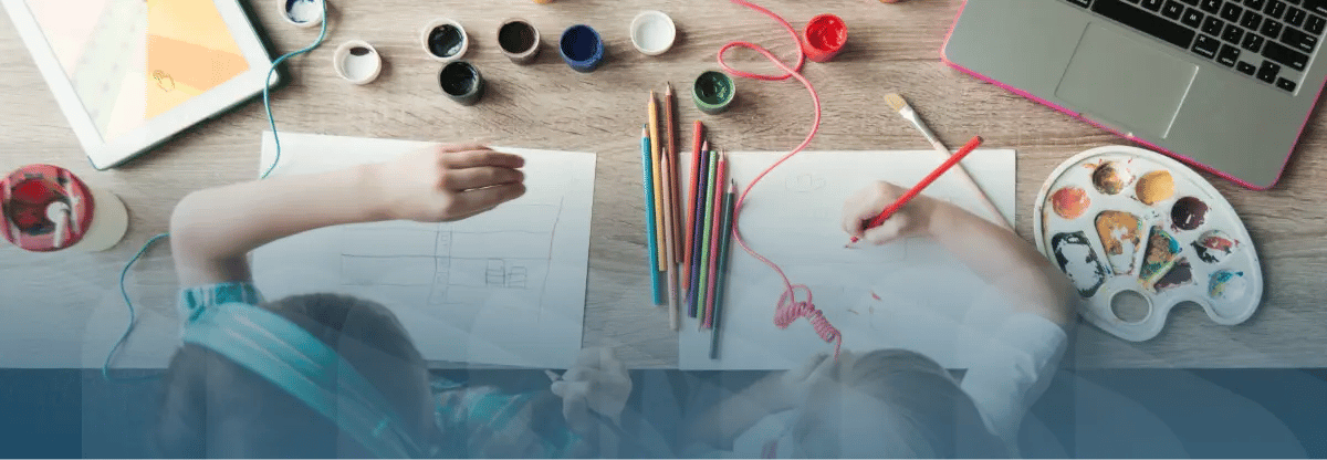 High angle of young kids working on arts and crafts at a table.