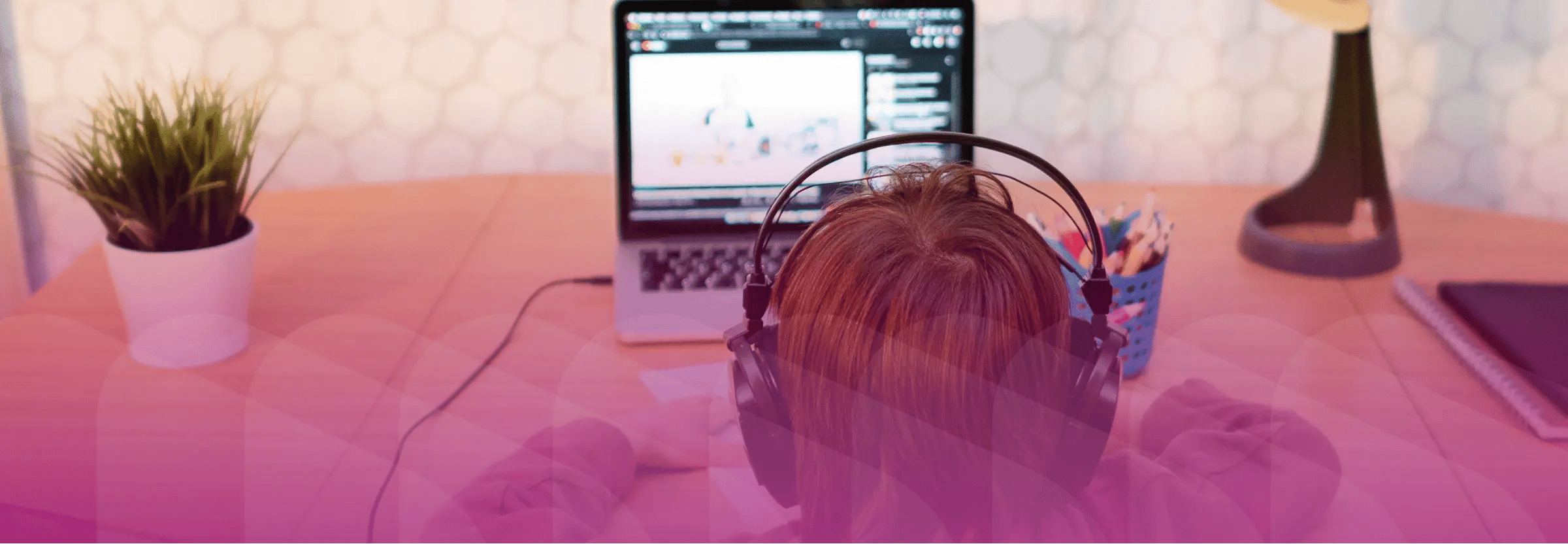 Young boy engaged in self-paced learning on computer. Magenta filter on top of image.