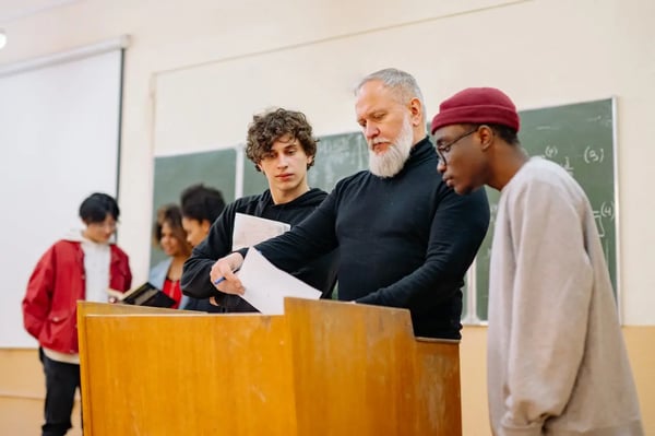 Higher ed students reviewing material with their instructor.