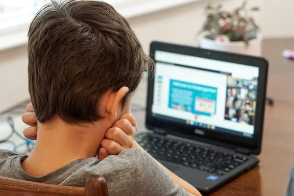 Student working asynchronously on laptop at home.