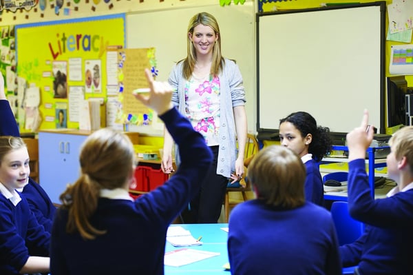 A structured discussion takes place in a flipped classroom with students and teacher having a conversation.