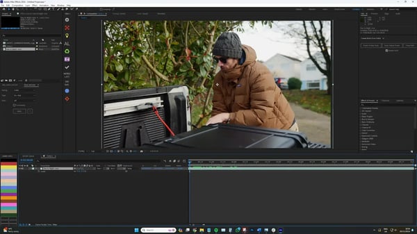 Producer in grey hat and brown coat outside shown through Adobe After Effects software.