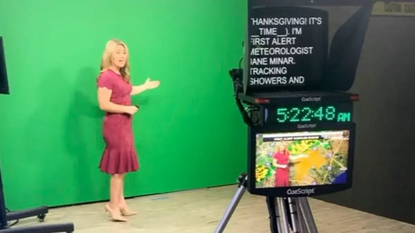 Female meteorologist in maroon dress from Fox News reporting on a green screen.