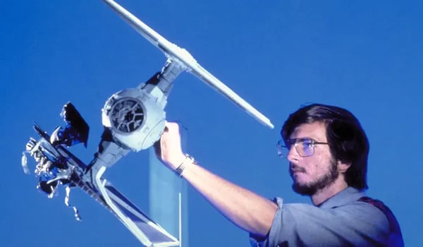 Blue screen image of brunette man with glasses holding a flying device.