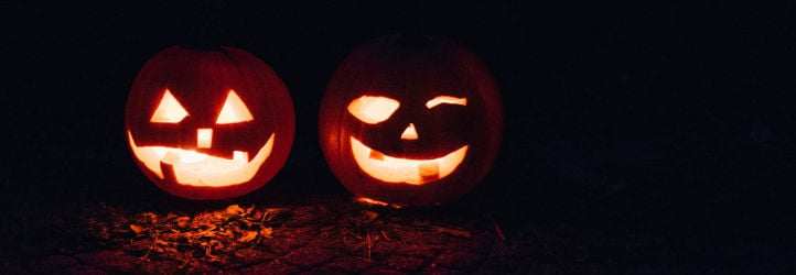 Two jack-o-lanterns in dark lighting.