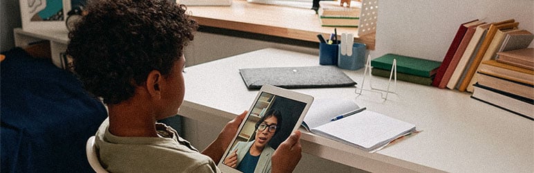 Young student holding a tablet while doing remote learning