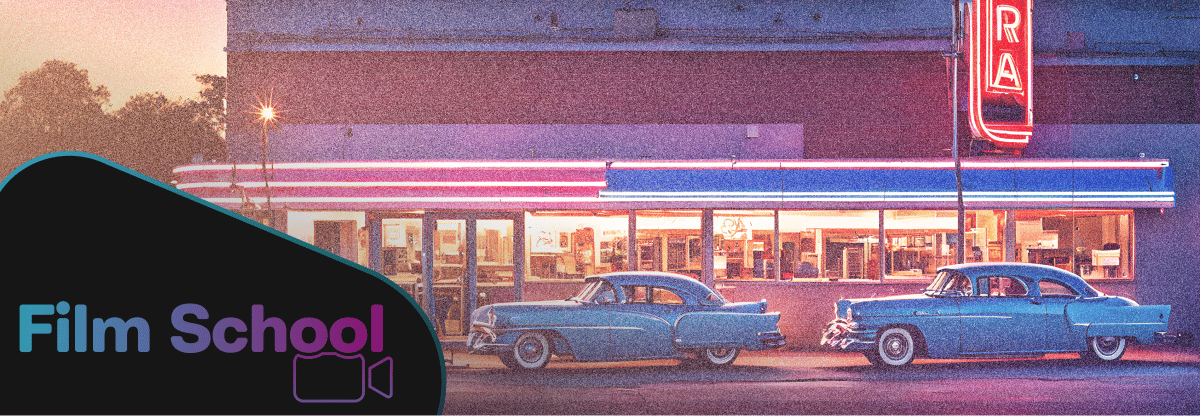 Two blue vintage cars sitting outside a diner at dusk lit with pink and blue LEDS and a film grain texture applied to it.