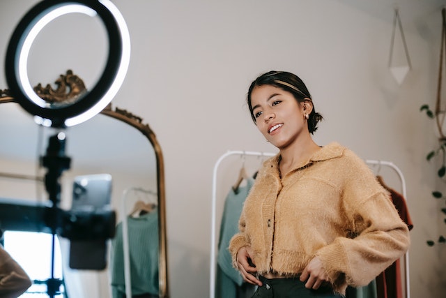 Woman posing for phone camera with LED ring light