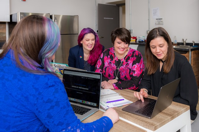 Women using laptops to make and watch training video content